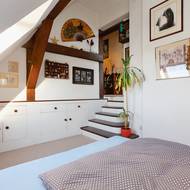 Do útulné ložnice v patře pod střechou s oknem se schází po pár schůdcích.