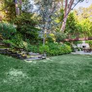 Po můstku z hlavní ložnice i po kamenných schodech je přístupná vířivka ukrytá mezi stromy. Klasický bazén však na zahradě není.