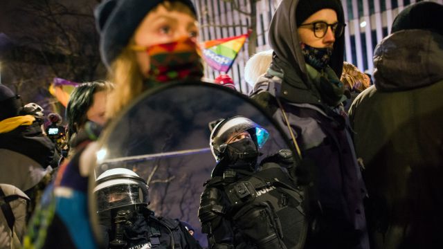 Demonstranti proti přitvrzení potratového zákona nastavují zrcadlo policistům. Lednový protest ve Varšavě.