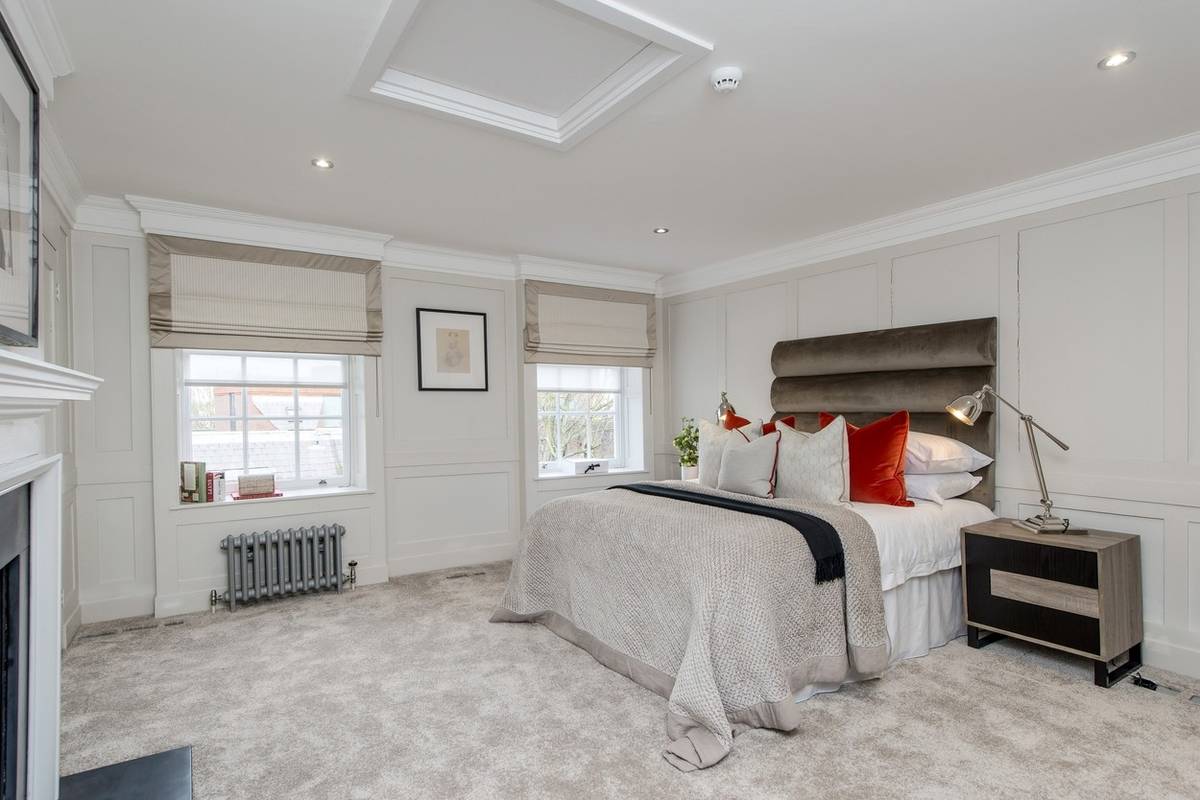 Hlavní ložnice má zachovaný původní krb. Praktičtějším zdrojem tepla je ale modernější radiátor.