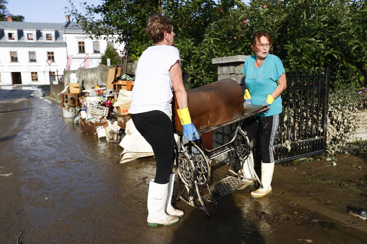 Lidé vynášejí šicí stroj ze zatopeného domu ve Starém Bohumíně