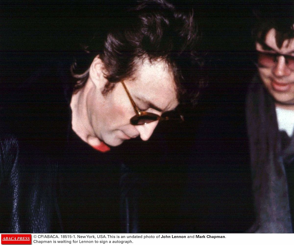 Jphn Lennon se svým vrahem Markem Chapmanem, když mu 8. prosince 1980 podepisoval album.