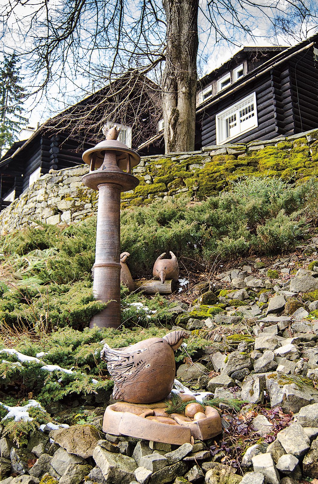 Svah s jalovci se osvědčil jako jeviště pro keramická dílka včetně originálních krmítek pro ptáčky.