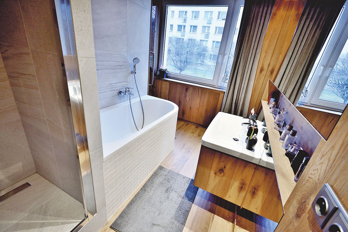 Obklady a dlažby v koupelně tvoří béžové keramické dlaždice (60 x 60 cm) ze série Random. 