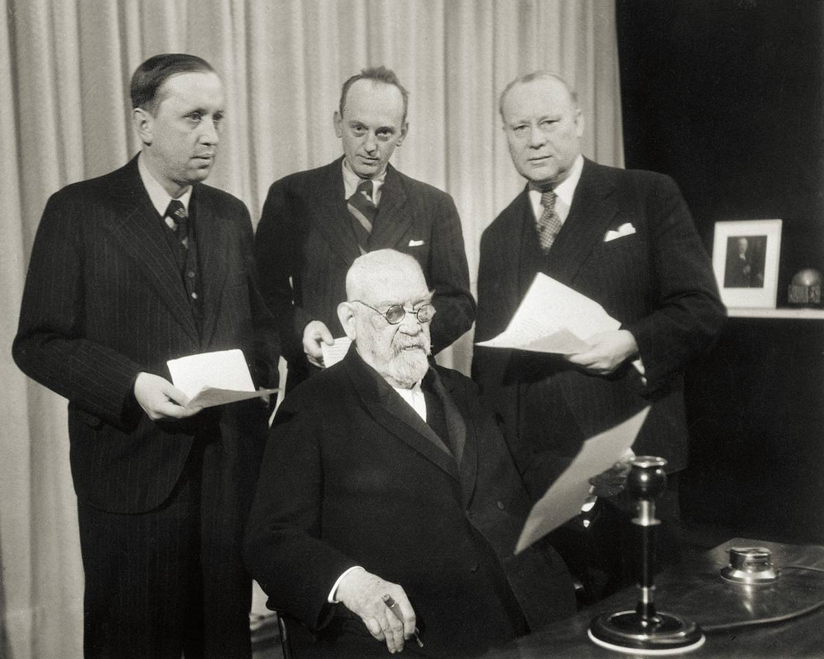 Československé rozhlasové stanice vysílaly 24. 12. 1937 poselství míru celému světu. Přednesli je František Křižík (sedící), spisovatel Karel Čapek (vlevo), překladatelé Otakar Matoušek a Vincenc Lesný.