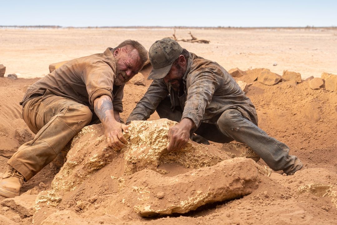 Anthony Hayes a Zac Efron se snaží vyjmout balvan zlata. 