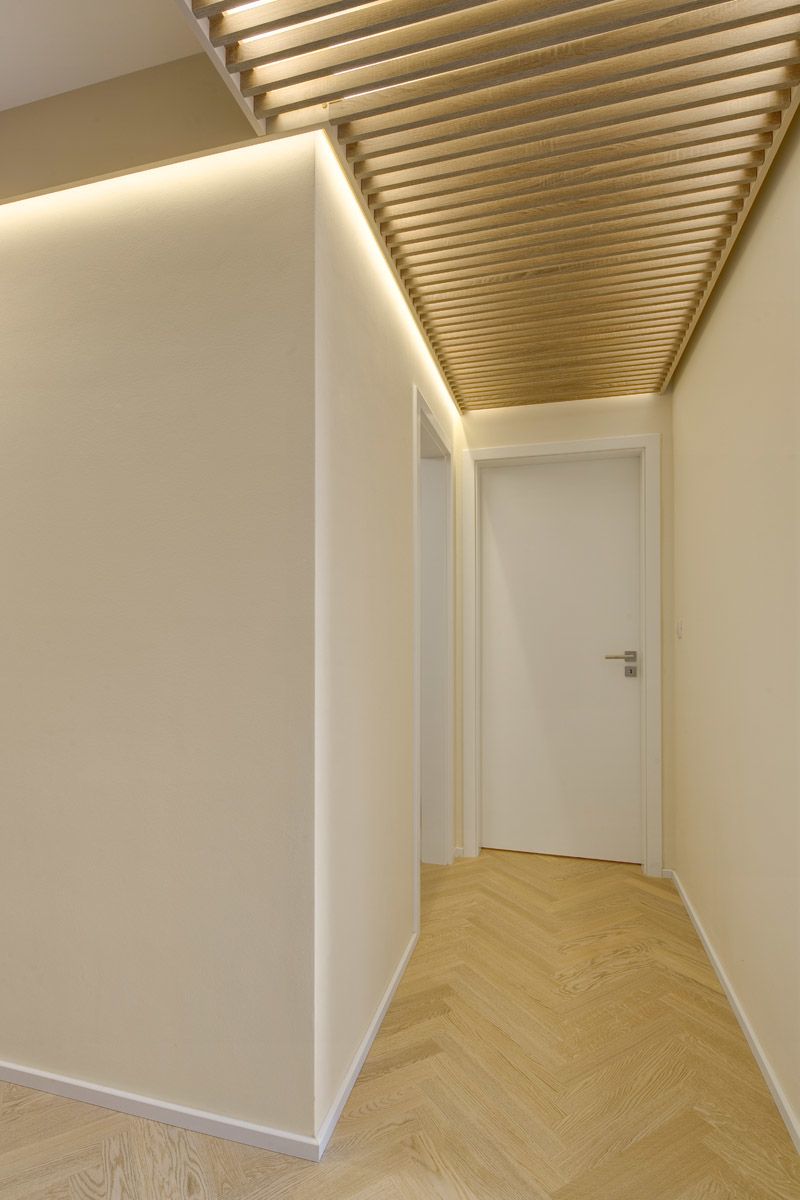 Původní strohá chodba je oživena originálním lamelovým podhledem a prostornými vestavěnými skříněmi.