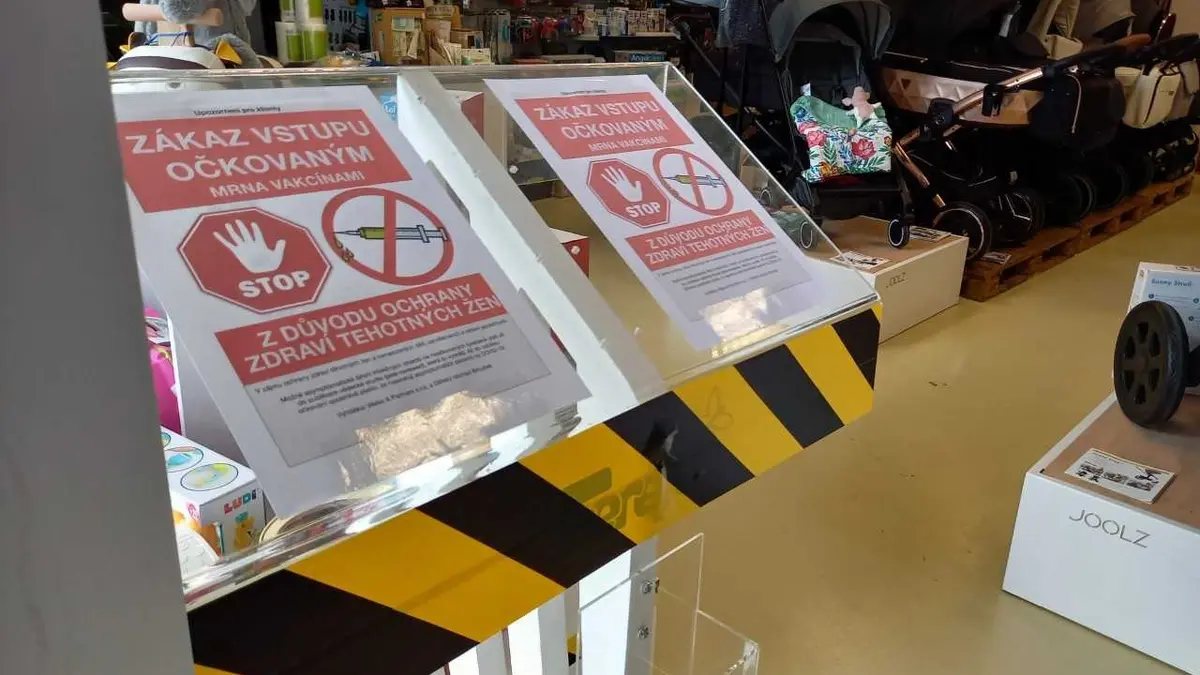 Dvě cedule zakazující vstup lidem očkovaným mRNA vakcínami proti novému typu koronaviru (na snímku z 23. června 2021) umístila u vchodu do obchodu s dětským zbožím nedaleko centra Olomouce jeho provozovatelka.