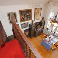 Jídelní stůl s výhledem na staroměstské střechy je kousek od praktické kuchyňky schované pod ochozem.