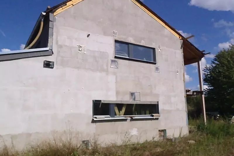 Pohled na dům, na jehož fasádě jsou vidět sondy do zateplovacího systému, které mají zjistit rozsah poškození nosné konstrukce.