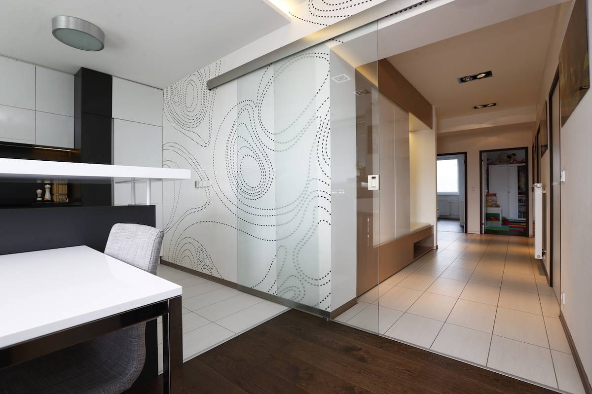 Široká chodba i díky skleněným dveřím propouští denní světlo celým bytem 3+1.