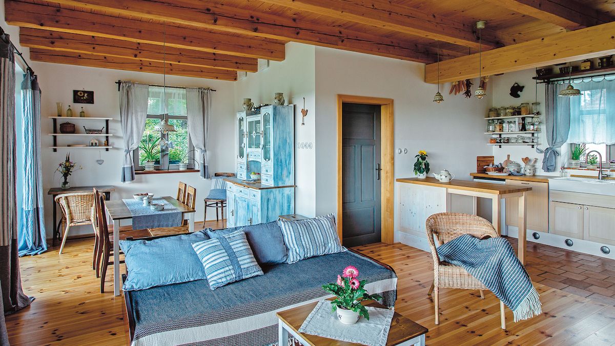 Lehké modré odstíny lněného bytového textilu se výborně doplňují s dřevěným materiálem nábytku, stropu i podlahy. 