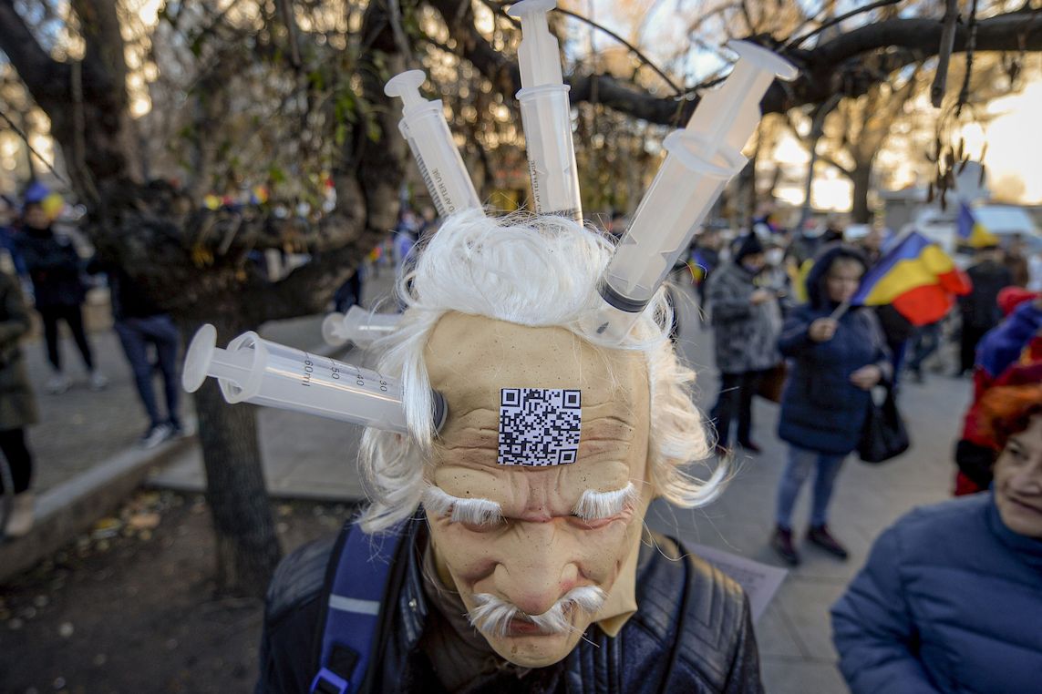 Muž v masce na demonstraci v Bukurešti