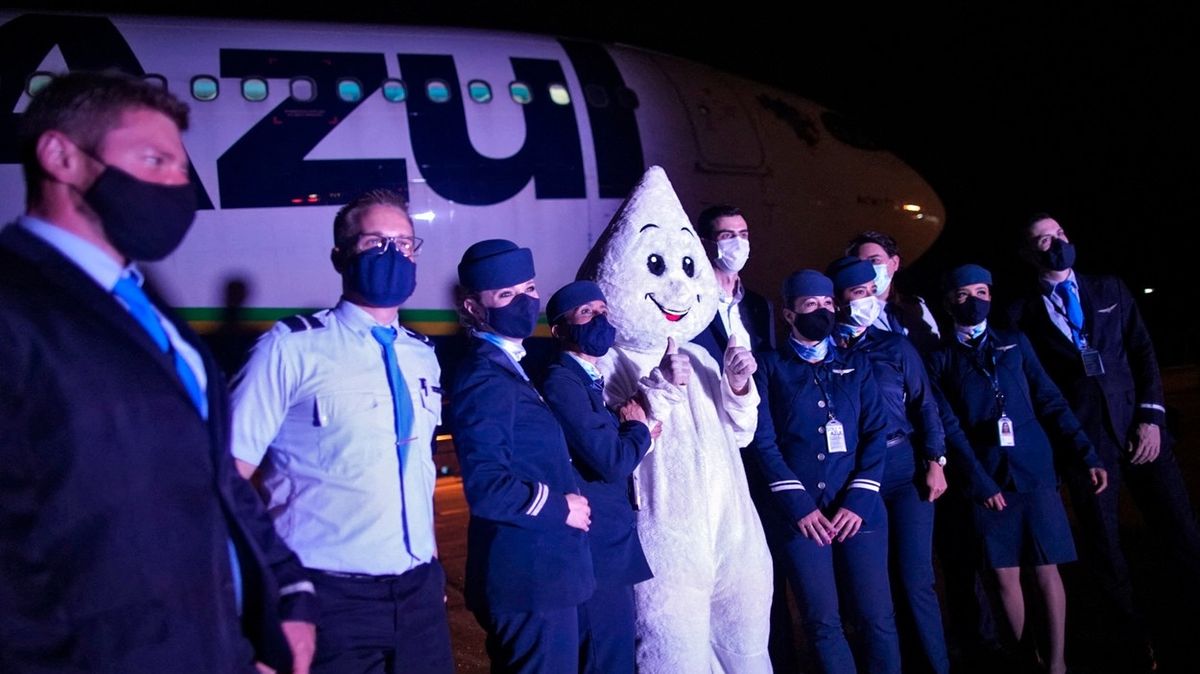 Maskot Zé Gotinha vítá na letišti první dodávku vakcíny AstraZeneca.
