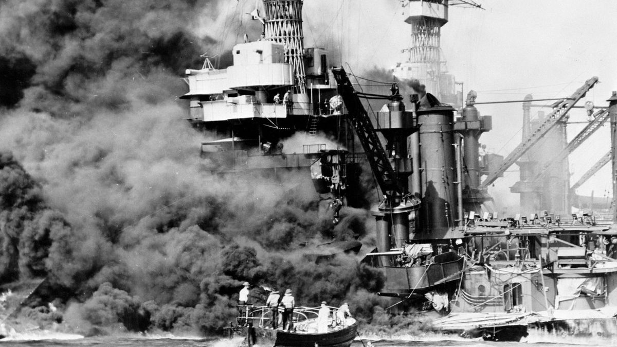 Záchranáři na Pearl Harboru míří k hořící lodi USS West Virginia.