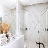 Nepříliš velká místnost je obložena mramorem a vybavena prostorným sprchovým koutem.