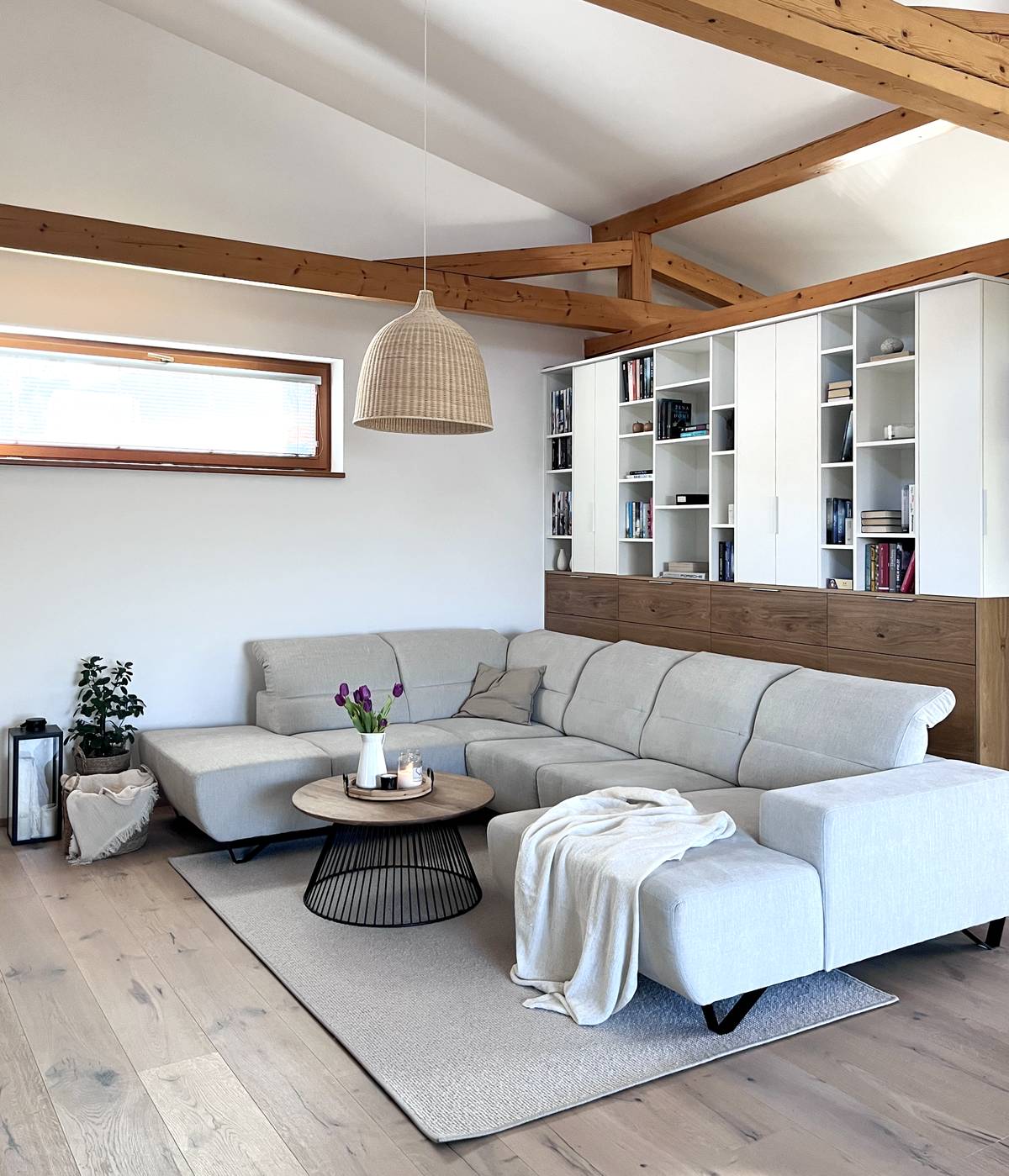 Centrálním prvkem obývací zóny je velká světle šedá sedačka.