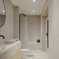 Úzká koupelna vypadá díky bílému obkladu prostornější.