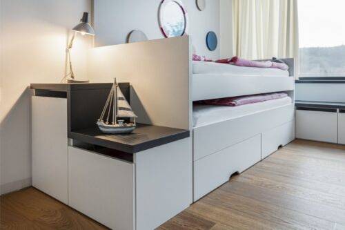 Stupínky vedle postele lze otevřít a schovat do nich třeba školní batoh.