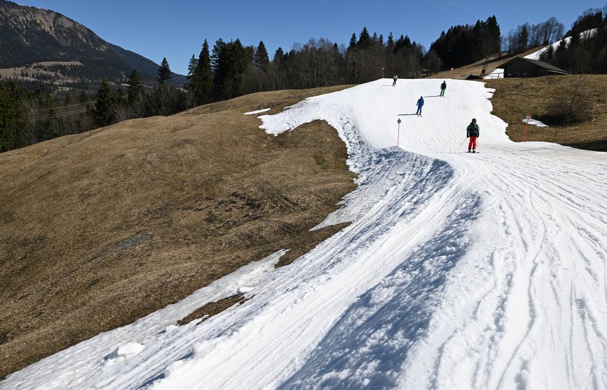 Lidé lyžují na vrstvě umělého sněhu poblíž alpského střediska Garmisch-Partenkirchen. 
