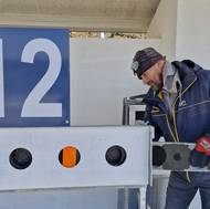 Pro elitní podnik nahrazuje správce střelnice tréninkovou sadu tou závodní, aby to při televizních přenosech hezky vypadalo.