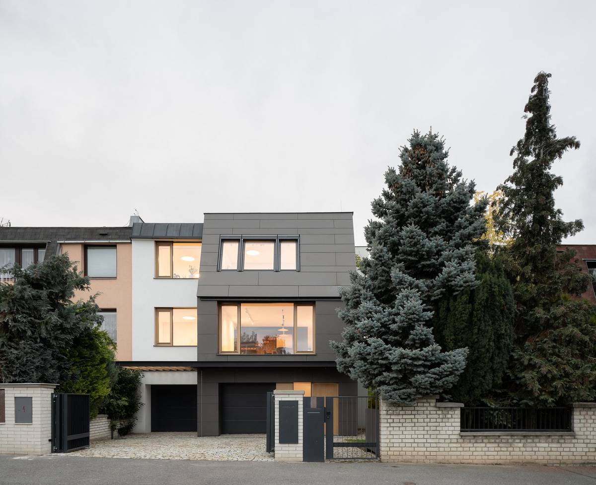 Stavba výškově i tvarově dobře zapadá do řady okolních domů.