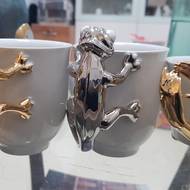 Hrnky s chameleonem. Mimo modrého  dekoru se hojně používá pravá platina i zlato.