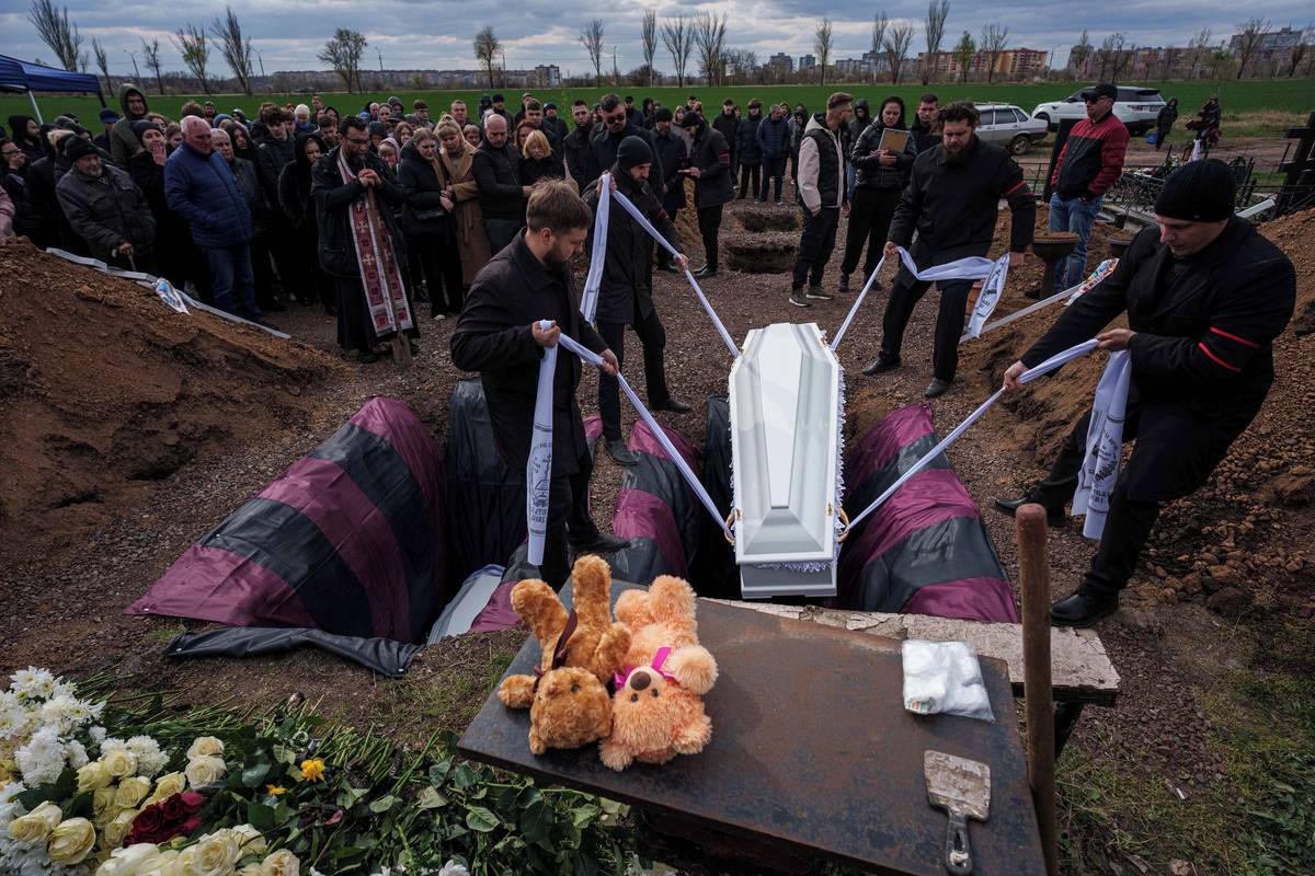 Zaměstnanci pohřebního ústavu ukládají do země rakve Danyla Nikitského (15) a Aliny Kutsenkové (15). Na Danyla pro AP zavzpomínala jeho kantorka Natalja Slobodeňuková, která uvedla, že byl „jiskra“, která nabíjela třídu energií a pomáhala organizovat školní výlety a další akce.