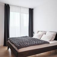 V ložnici architekti kombinují odstíny šedé, hnědé a bílou barvou. Vytvářejí tak příjemnou a útulnou atmosféru.