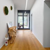 Na protější straně od vchodových dveří chodbu prosvětlují velkoformátové dveře, skrze které lze vyjít na zahradu.