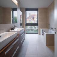 Ve vile jsou celkem tři koupelny. První se nachází v blízkosti hlavní ložnice a je vybavena jak velkou prostornou vanou, tak i sprchovým koutem. Zbývající dvě koupelny architekti situovali do horního patra.