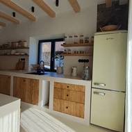 Zděná kuchyň má dřevěná čelní dvířka zhotovená svépomocí.