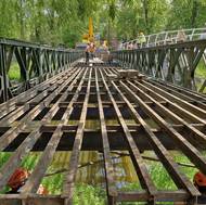 Technici ve středu odstrojovali válečný most Bailey Bridge, aby ho mohli ve čtvrtek přesunout mimo řeku. Nejdřív odstranili dřevěnou mostovku.