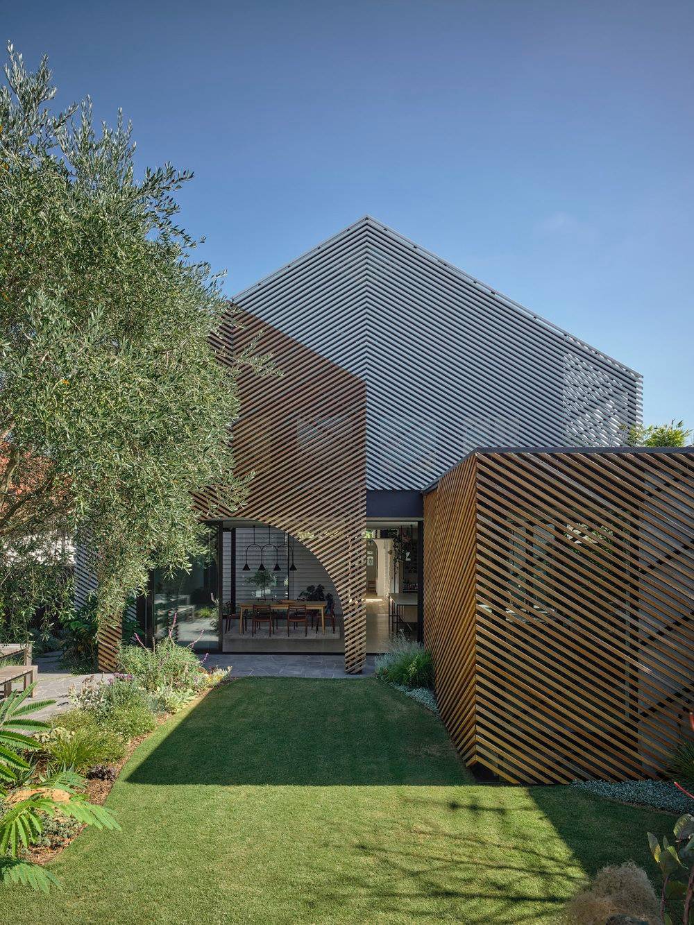 Části nové přístavby se vzájemně překrývají. Celek tak působí zajímavě a dynamicky. I díky laťoví.