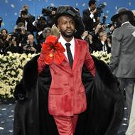 Jamajský módní návrhář Edvin Thompson vynesl červený oblek své značky Theophilio doplněný broží obřího ibišku na zakázku.