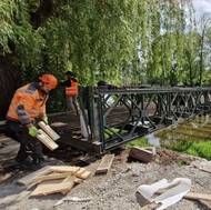 Technici ve středu odstrojovali válečný most Bailey Bridge, aby ho mohli ve čtvrtek přesunout mimo řeku. 