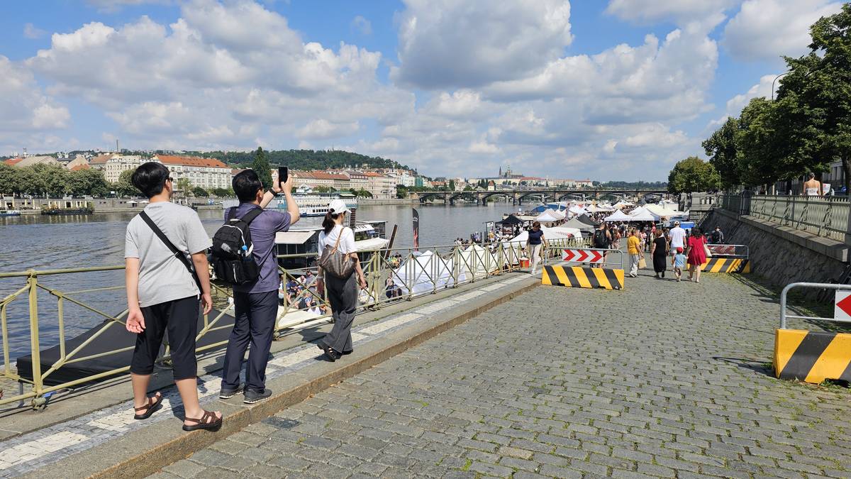 Turisté si fotí výhled na Pražský hrad a trhy, které se zde konají každou sobotu.