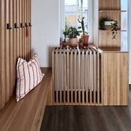 Radiátor je šikovně schovaný za dřevěnými latěmi. Ve skříňce po straně je přístup k ovládání topení.