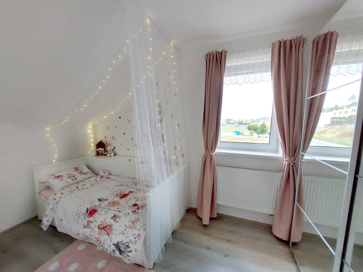 Baldachýn proměňuje rozkládací postýlku v pohodlné útočiště. Barevná paleta pokoje zahrnuje oblíbenou holčičí růžovou a bílou.