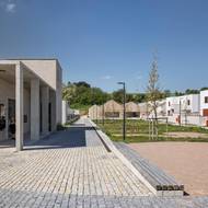 Nechybí náměstí s centrem služeb, sokolovnou a obecním bytovým domem. 