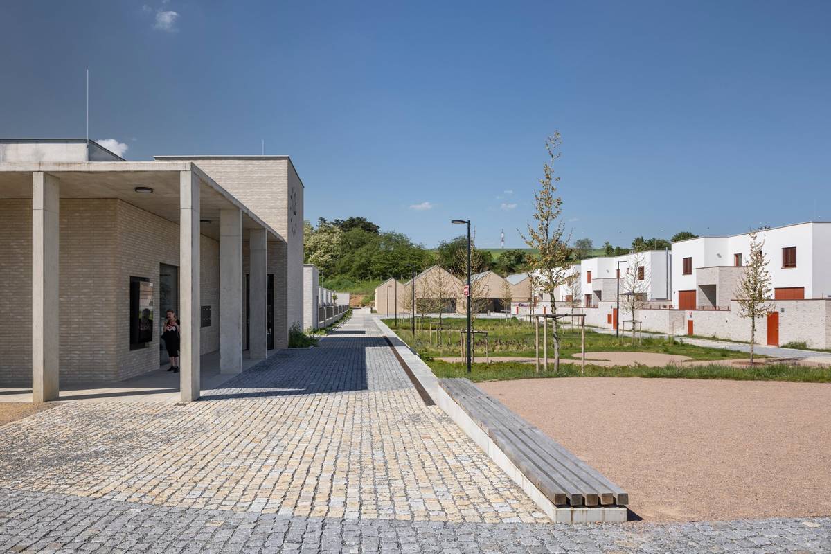 Nechybí náměstí s centrem služeb, sokolovnou a obecním bytovým domem. 