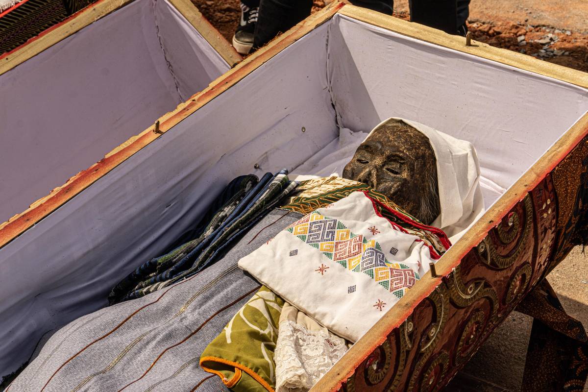 Tamní obyvatelé vytahují rakve z hrobek, které následně otevírají.