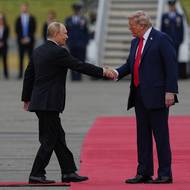 Trump podává ruku Putinovi.
