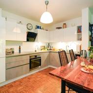 Jídelní stůl je předělem mezi elegantně střídmou kuchyní a obývacím pokojem – v jeho interiéru nechybí historizující nábytek.