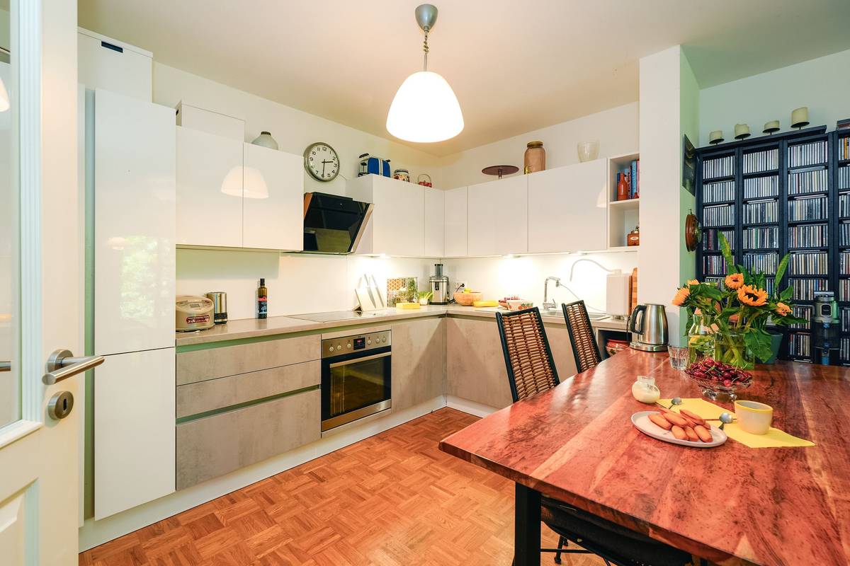 Jídelní stůl je předělem mezi elegantně střídmou kuchyní a obývacím pokojem – v jeho interiéru nechybí historizující nábytek.