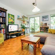 Velká okna v novostavbě bytového domu prostor opticky zvětšují i v obývacím pokoji s kuchyní. Knihovna je putovní a byla i v minulých, pronajatých bytech.