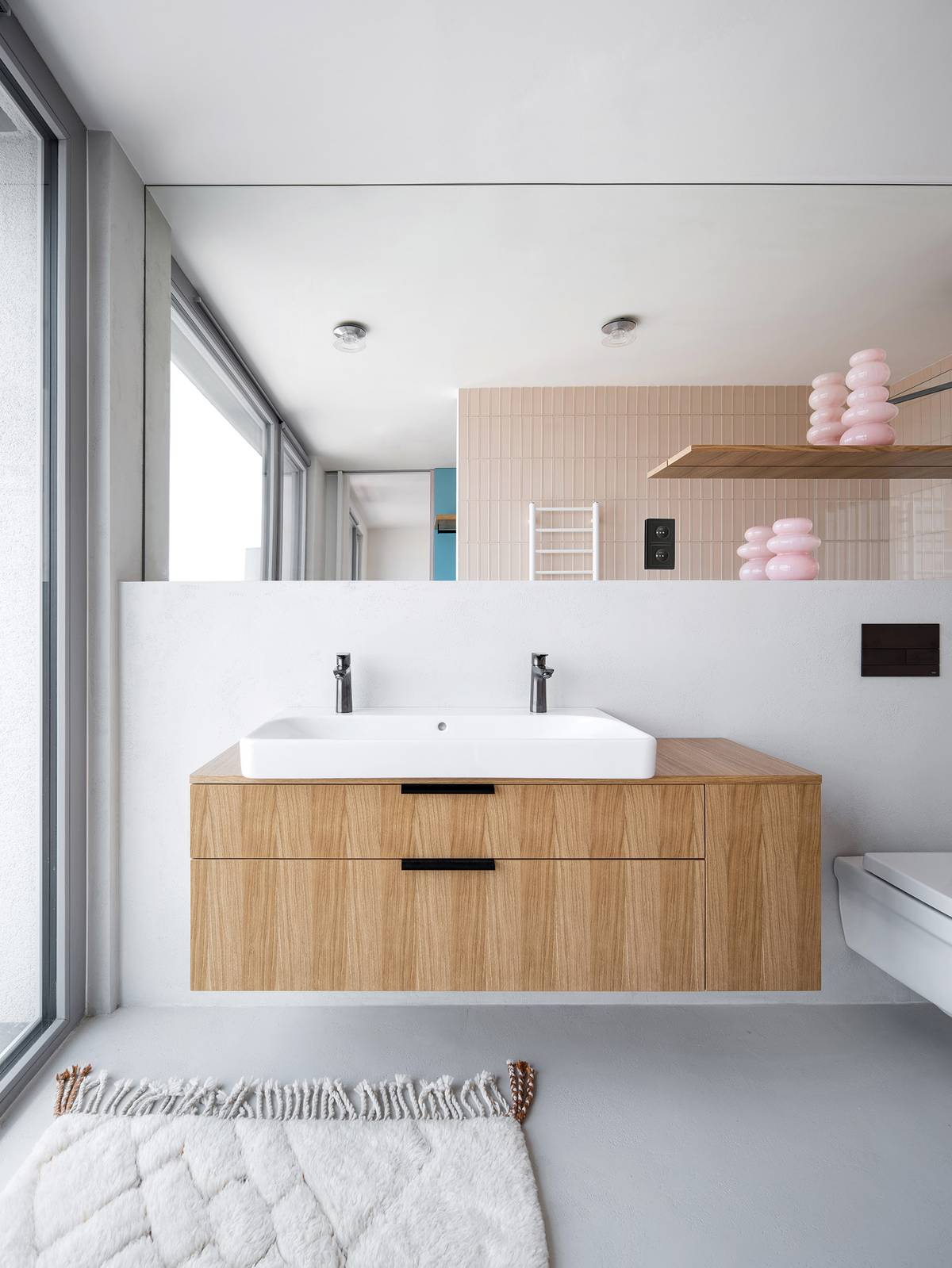 Základem je podlaha a stěny opatřené stěrkou, která je doplněna drobnějším, barevně výraznějším keramickým obkladem. Dřevěná skříňka je na míru vyrobena truhlářem. Dřevo je v koupelně potřeba důkladně ošetřit tak, aby bylo možné jej použít do vlhkých prostor.