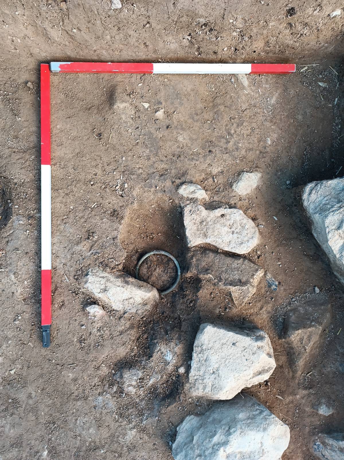 Odkrytá část hrobu s bronzovým náramkem