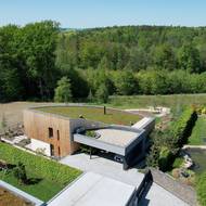 Při pohledu shoda je vidět, že stavba díky své zelené střeše dobře splývá s okolím. 