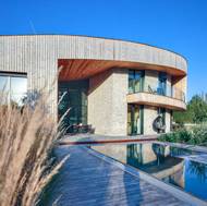 Majitelé si mohou užívat i bazénu, který na stavbu hezky navazuje a tvoří s ní designově jednotný celek.